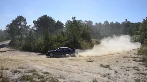 Subary rally car taking a medium speed S corner on a rally course Stock Footage 74397880