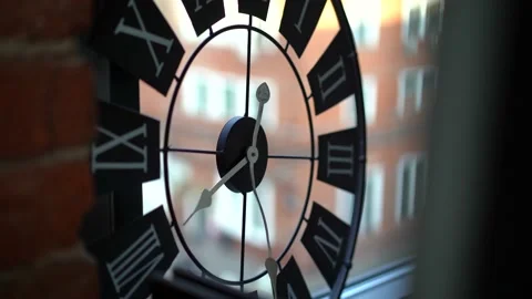 Subject: black wall clock with white Roman numerals and white hands  Stock Footage 133437345