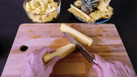 Subjective first-person view of hands cutting a slice of pineapple into pieces Stock Footage 126645928