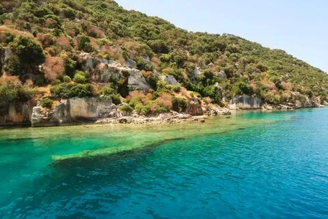 Submerged wall next to remaining structures onshore at the ancient sunken c.. Stock Photos