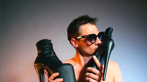 Submissing a man in glasses sniffs the shoes of dominant woman at kinky party. Video stock 124692791