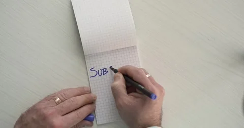 Subscribe  - this word is written on the sheet by a man's hand Stock Footage 267084623