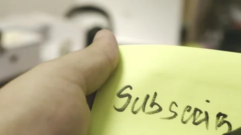 Subscribe. Writing with black marker on a sticky note Stock Footage 318357496