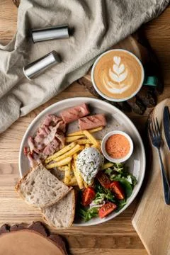 Substantial breakfast in a cafe with bacon, roasted sausage poached egg and s Stock-Fotos