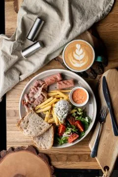 Substantial breakfast in a cafe with bacon, roasted sausage poached egg and s Stock Photos