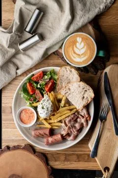 Substantial breakfast in a cafe with bacon, roasted sausage poached egg and s Stock-Fotos