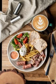 Substantial breakfast in a cafe with bacon, roasted sausage poached egg and s Stock Photos