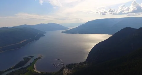 Subtle aerial tracking shot of large lake surrounded by mountains in BC Canada Video stock 113978684