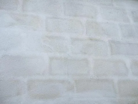 Subtle block pattern showing through light grey plastered wall, minimalist .. Stock Photos