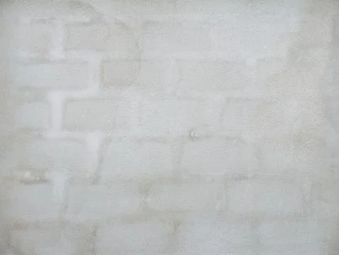Subtle block pattern showing through light grey plastered wall, minimalist .. Stock Photos