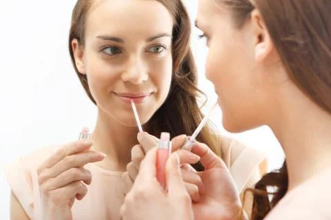 Subtle makeup - brunette paints lips with lipstick  Stock Photos