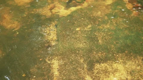Subtle movement of clear water over rock texture. Loop. Видео 332964403