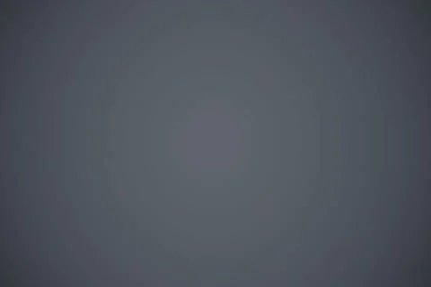 Subtle radial gradient is being shown on smooth uniform grey surface in flat Stock Photos