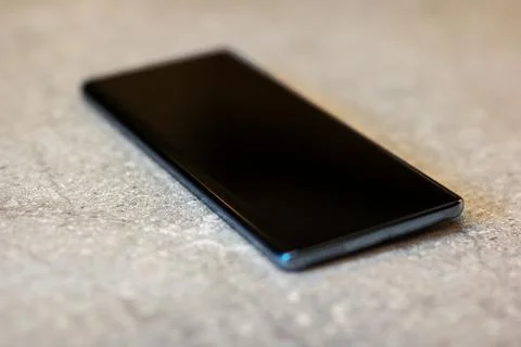 Subtle reflection of sleek mobile device lying on plush carpet in warm Stock Photos