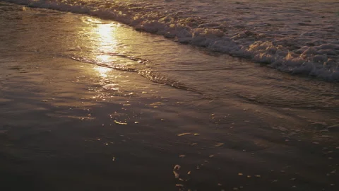 Subtle Wave Patterns and Foam in Calm Coastal Morning Stock Footage 327630181