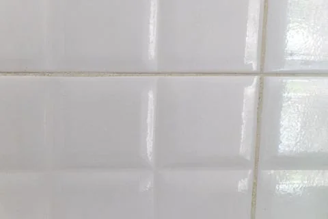 Subtle white ceramic bathroom tiles with cream decorative repeating texture. Foto stock