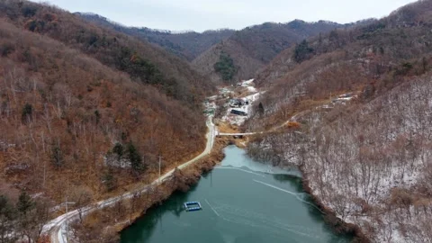 Suburb town surrounded by winter mountain &amp; frozen lake, South Korea - 4K Aerial Stock Footage 327622217