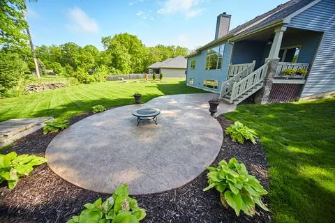 Suburban Backyard with Fire Pit and Lush Lawn, Eye-Level View Foto stock