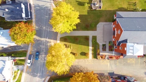 Suburban town with bright trees and church parking lot in fall, warm hues of Video stock 305533599