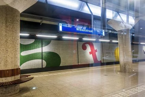 Suburban train passing the empty subway platform of Wibautstraat Station Stock Photos