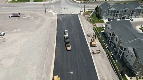 Suburban Utah roadwork development aerial view flying down new asphalt Stock Footage 245691915