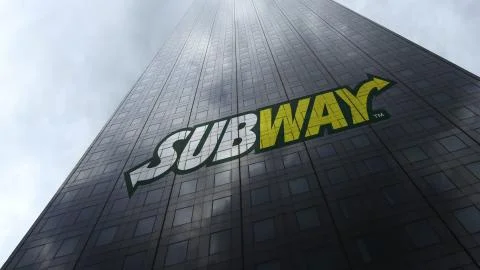 Subway logo on a skyscraper facade reflecting clouds. Editorial 3D rendering Stock Illustration