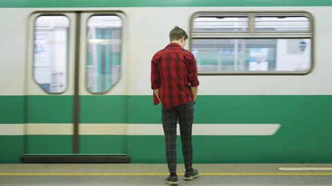 A subway, a man is standing, a subway train arrives, a guy enters the train car. Stock-Footage 209222540
