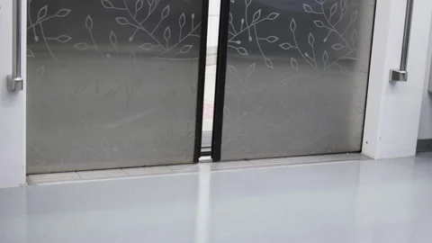 Subway platform screen doors close. Smooth glass, metal surfaces reflect light Stock Footage 322045490
