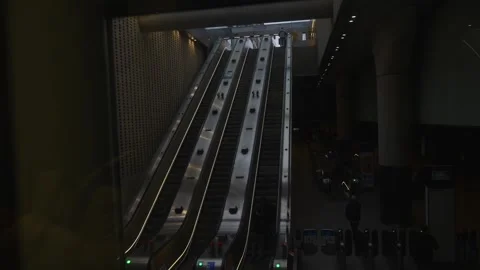 A subway station with two escalators and a few people Stock Footage 297859450