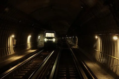 Subway train approaching in dark metro tunnel 스톡 사진