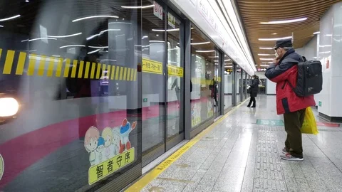 Subway Train Arrives while Two People Wearing Medical Masks Wait at the Station Stock Footage 124677612