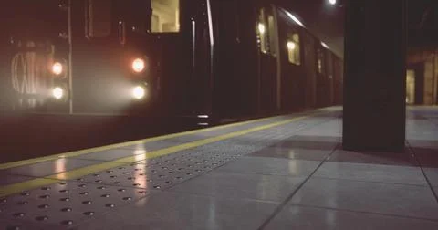Subway train arriving at platform during nighttime in urban setting Illustrazione stock