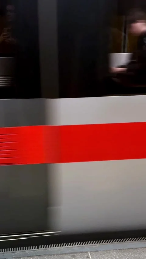 Subway train car speeding past platform, showing motion blur, red stripe, white Stock Footage 333110662