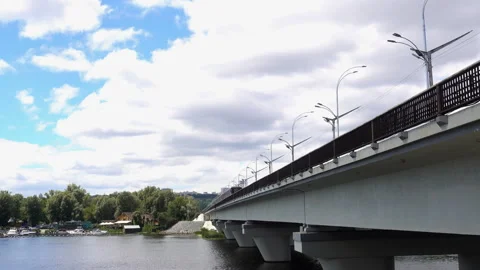 Subway train crosses the bridge over the river in 4K. Video stock 136823379