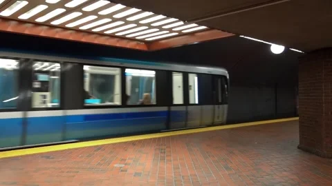 A subway train moves quickly past a brick underground station platform Stock Footage 347726228