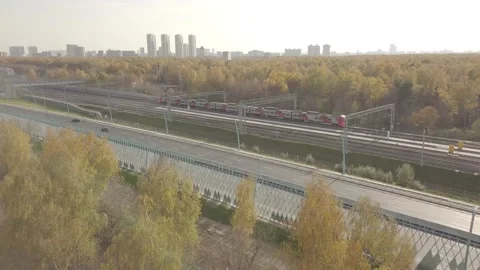 The subway train is moving next to a busy highway Stock Footage 164557895