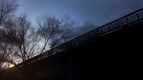 Subway Train Passes Over the Bridge at the Evening Sunset Stock Footage 45390639