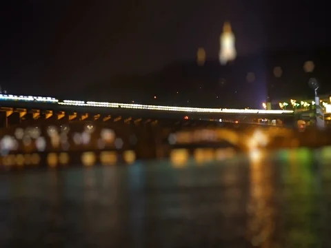 Subway train passes over the luminent river at night Stock Footage 71865647
