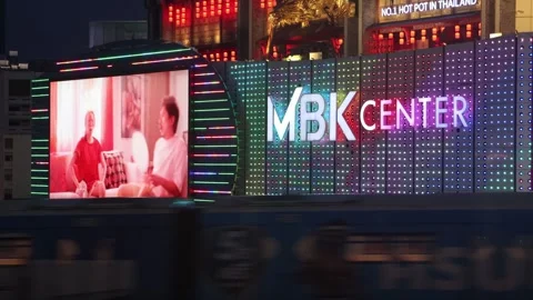 A subway train passes under a facade with colorful illuminated advertising Stock Footage 315430900