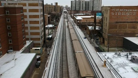 Subway train passing along snow covered tracks in urban Chicago Stock Footage 101746107