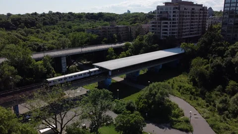 Subway train pulling out of above ground station drone shot 動画素材 137108919