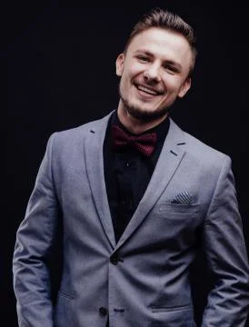 Succes guy in gray jacket looking with butterfly smiling on dark background Stock Photos