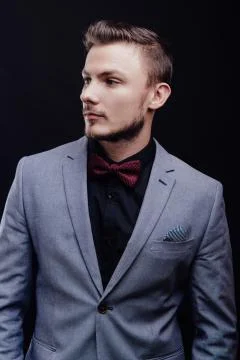 Succes guy in gray jacket looking to the right on dark background Stockfoto's