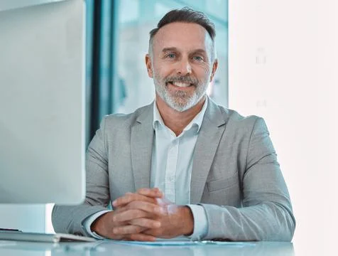 Success is best when its shared. a mature businessman sitting at a desk at work. Stock Photos