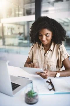 Success driven by smart tech. a young businesswoman using a digital tablet at Stock Photos