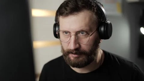 Success, I agree, cool concept. Friendly man in glasses and headphones at comput Stock-Footage 303948060