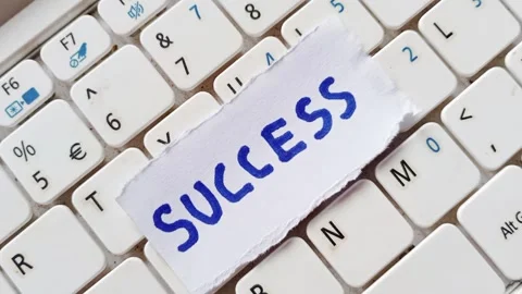 Success memo written blue on piece of paper. Letters words, on a laptop keyboard Stock Footage 304909858