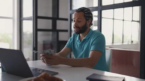Successful African American man counting money after online investments Stock Footage 332803608