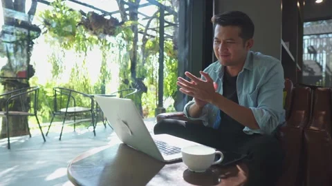 Successful asia young businessman using laptop while sitting in cafe. 動画素材 234975341
