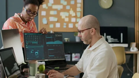 Successful Black Female Boss Checking Work of Male Programmer in Office Stock Footage 306849146